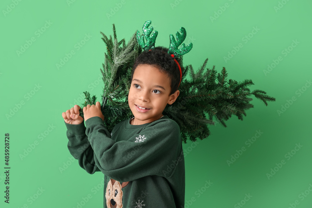 Cute little African-American boy with Christmas tree on color background