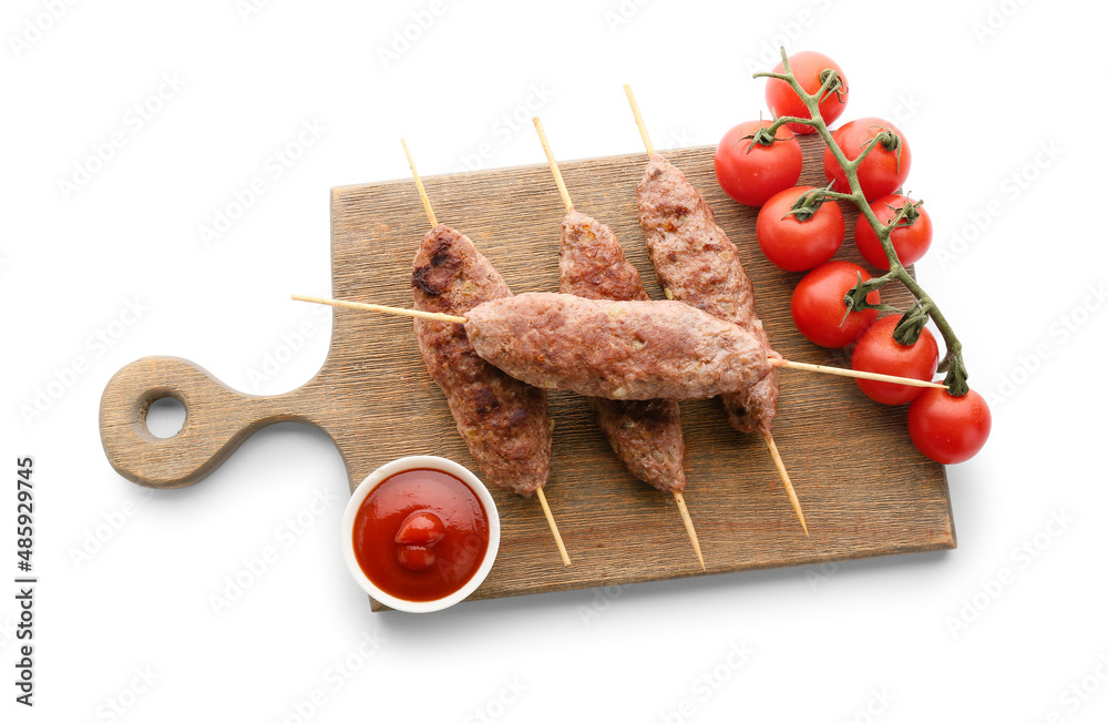 Wooden board of skewers with tasty lula kebab, tomatoes and sauce isolated on white background