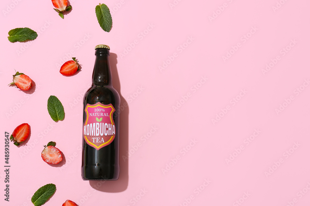 Bottle of tasty strawberry kombucha and mint on pink background