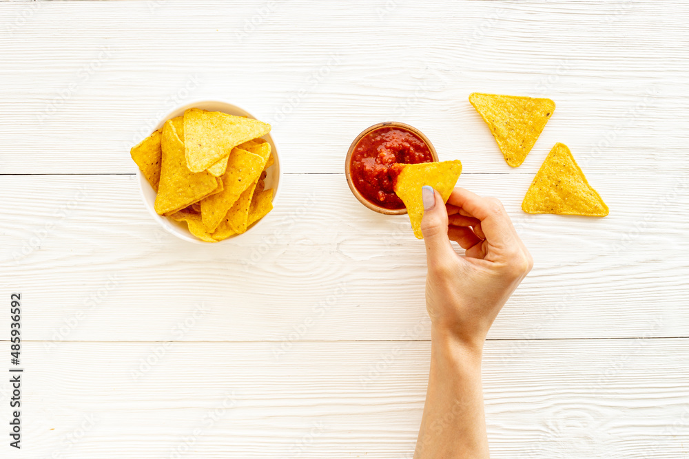 Mexican food nachos chips with tomato salsa sauce, top view