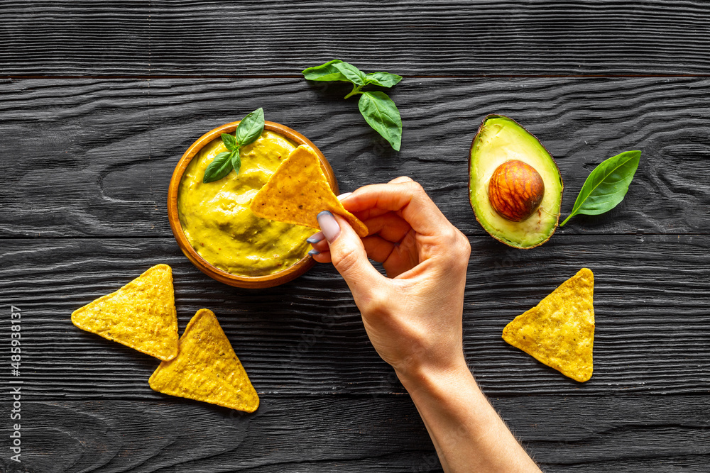 Avocado guacamole sause in bowl with nachos chips