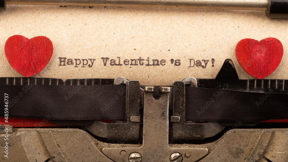 Happy Valentine`s day - phrase on typewriter. Valentines Day greetings concept. Little red wooden he