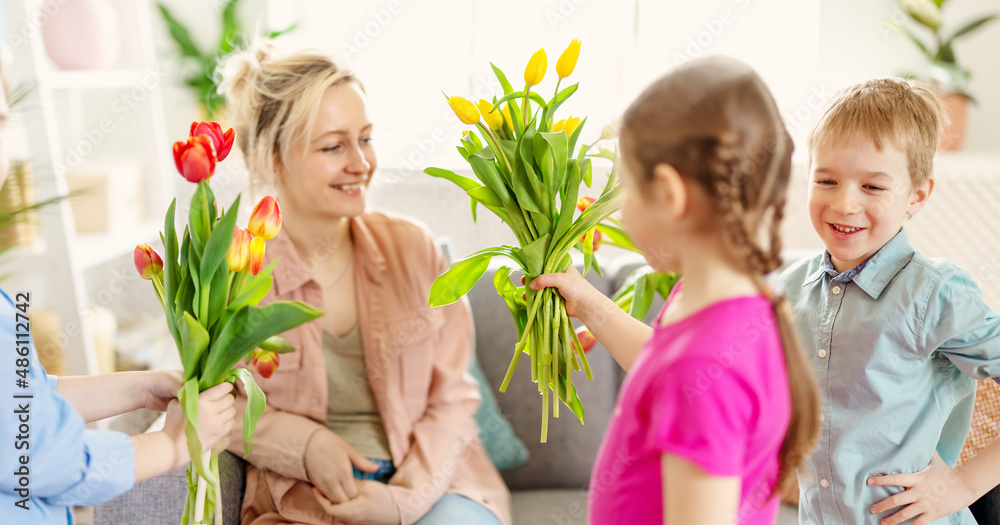 可爱的孩子们把她们美丽的母亲送给花束。