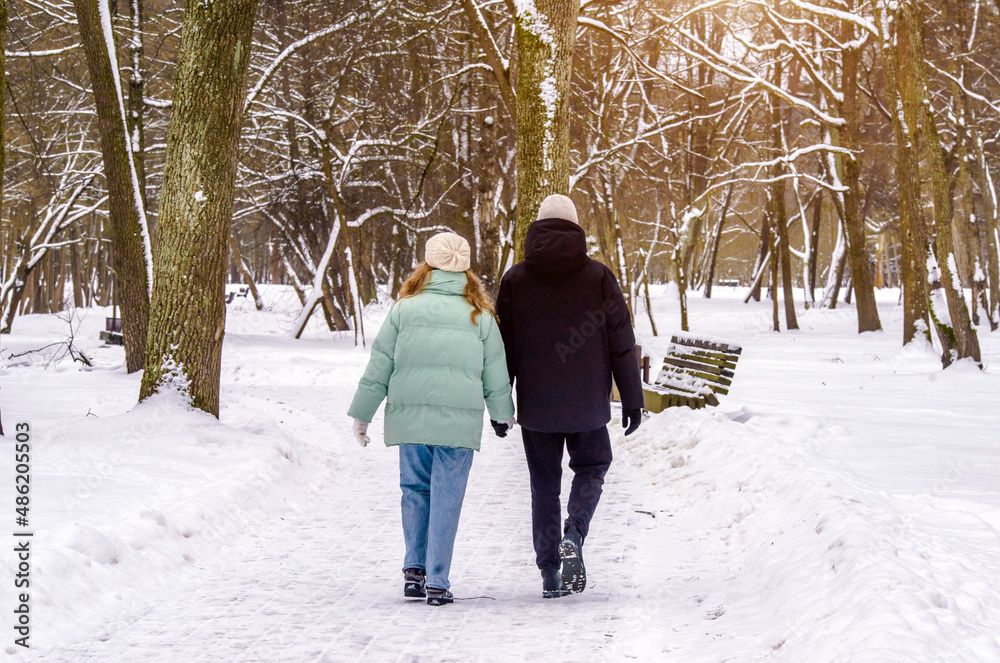  A guy and a girl walking in winter Park
