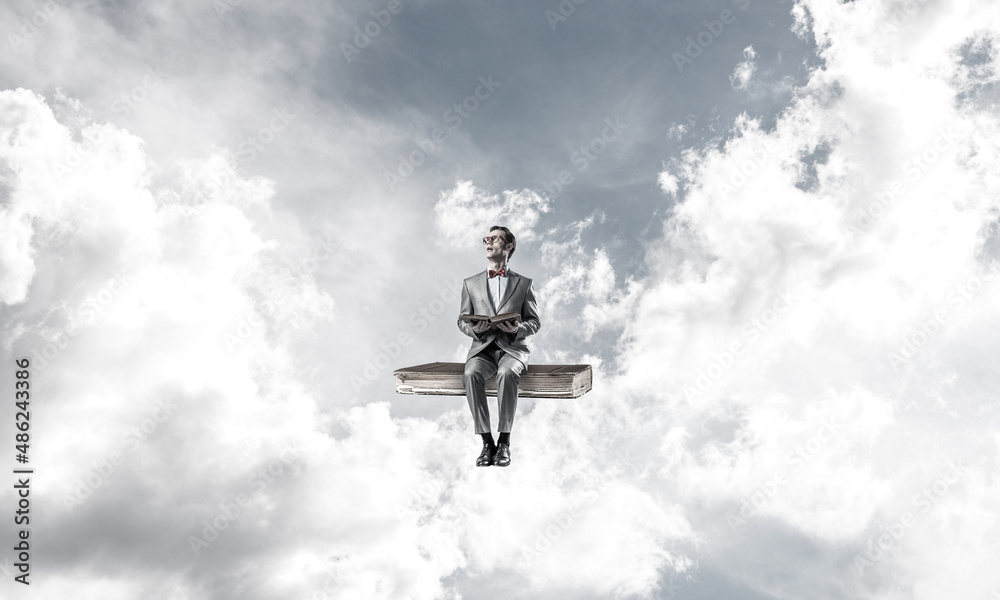 Young businessman or student floating in blue sky and studying the science