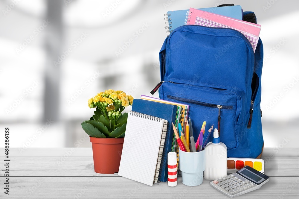 Bright backpack on table home. School supplies. Back to school concept. Educational design objects.