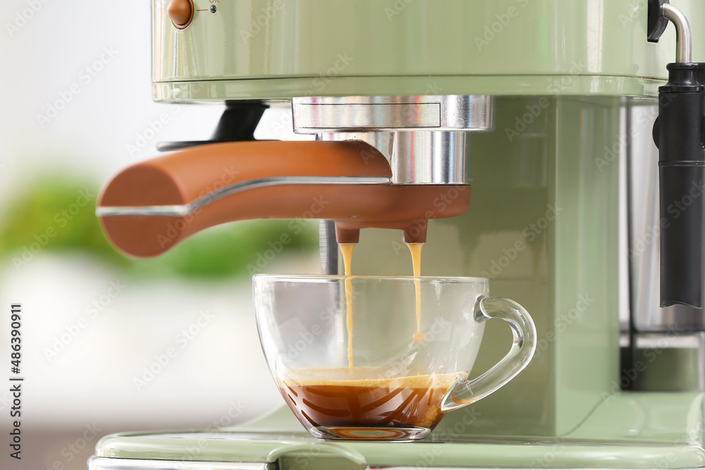 Preparing fresh espresso with coffee machine in kitchen