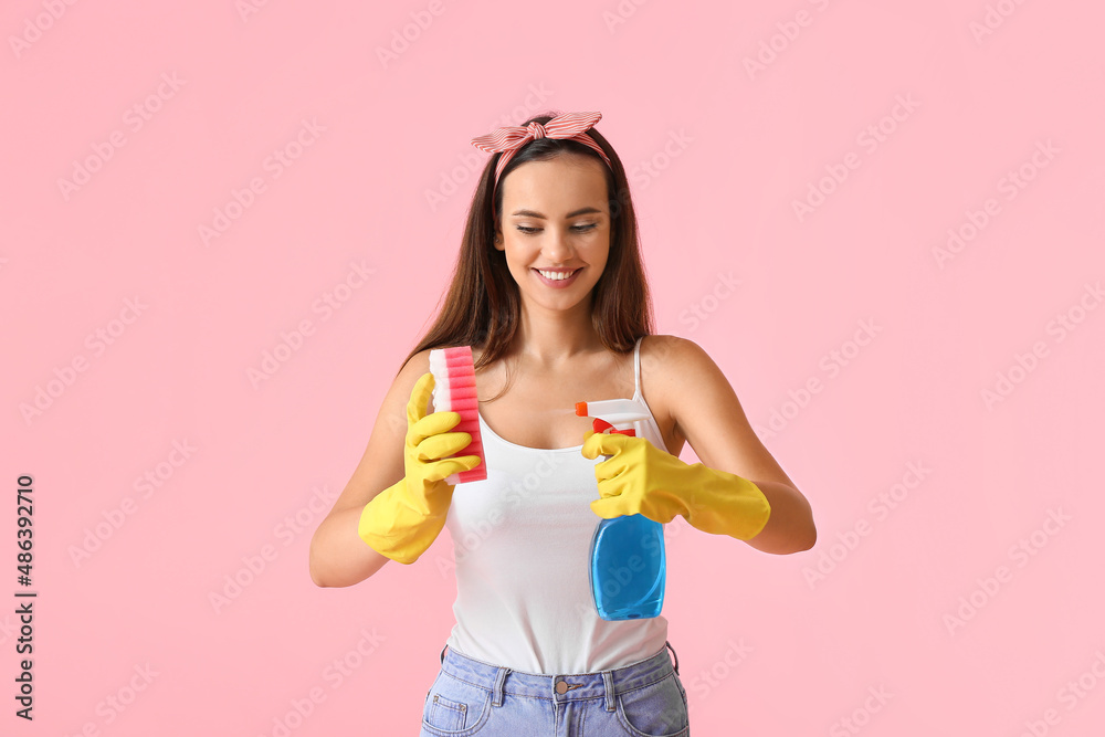 Young woman with sponge and detergent on color background