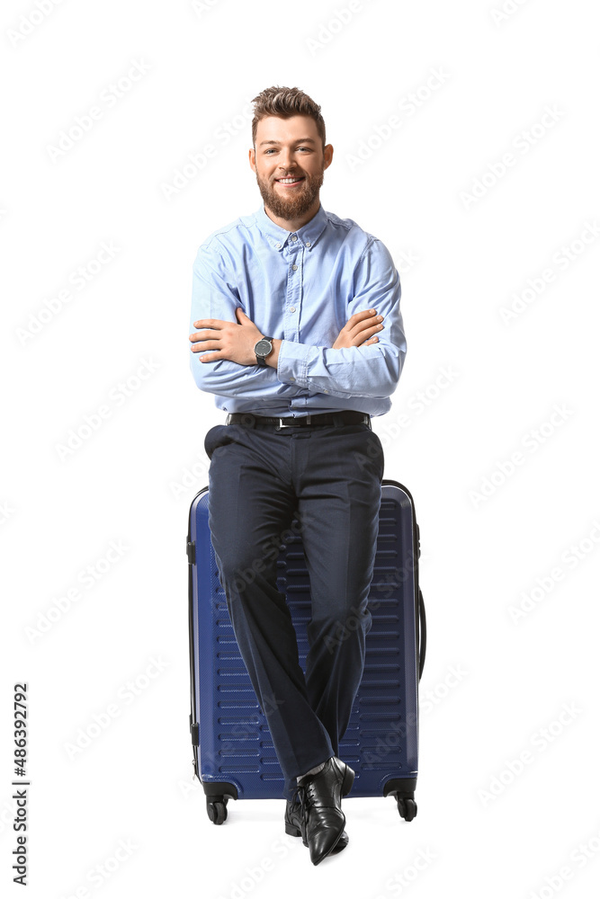 Handsome businessman with blue suitcase on white background