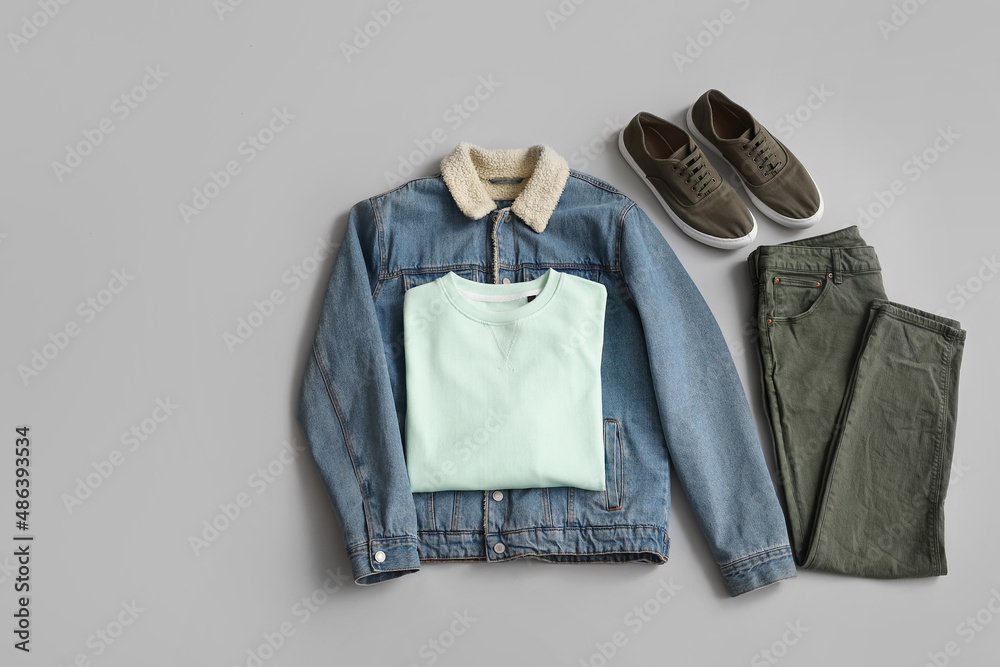 Stylish male clothes with sneakers on grey background