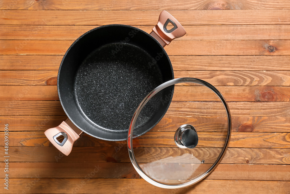 Cooking pot and lid on wooden background