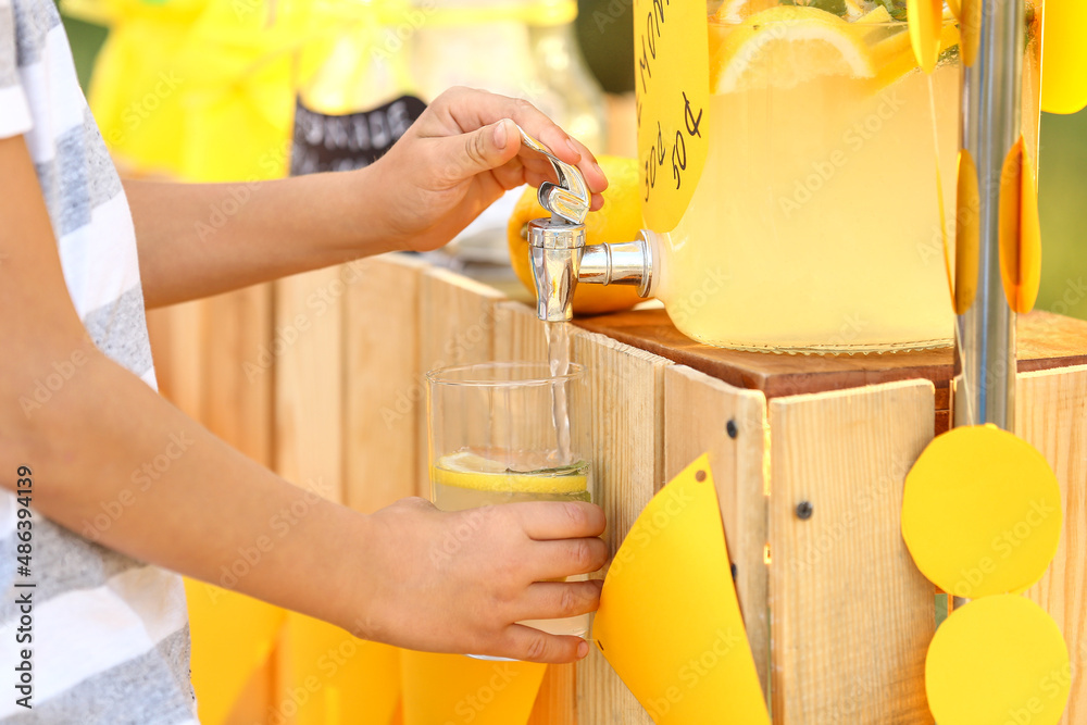 Cute child buying lemonade in park, closeup