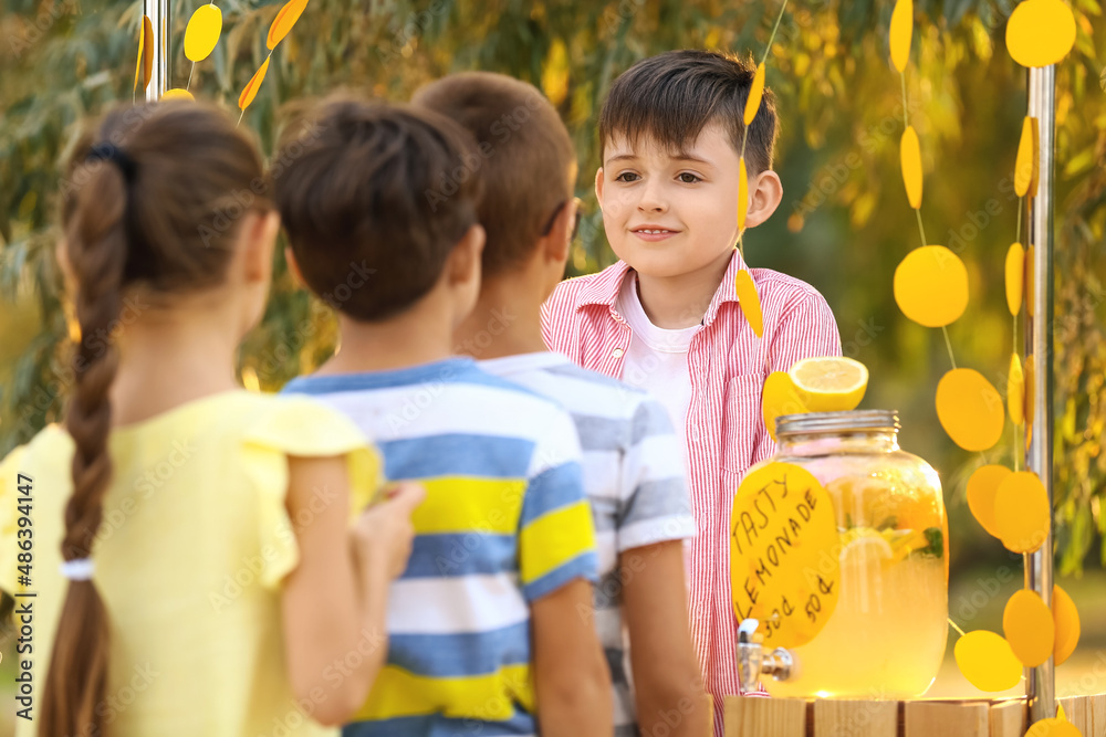 Cute children buying lemonade in park