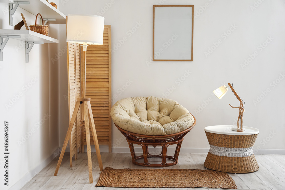 Interior of stylish living room with armchair, lamps and wicker coffee table