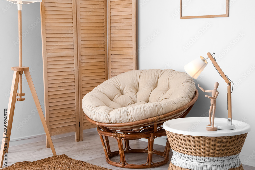 Interior of stylish living room with armchair and wicker coffee table