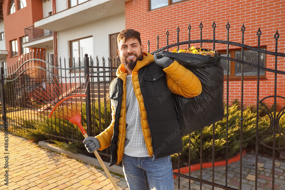 Man gathering autumn leaves outdoors