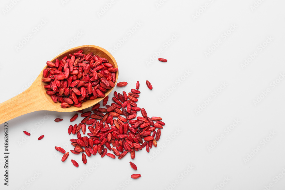 Spoon with dried barberries on white background