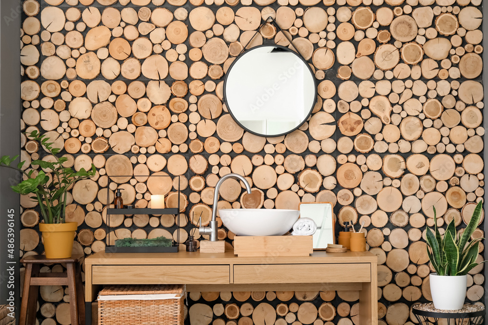 Box with sink and bath supplies on table near wooden wall