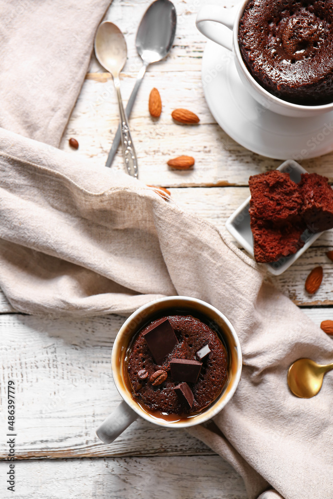 Cups with tasty chocolate brownie on white wooden background