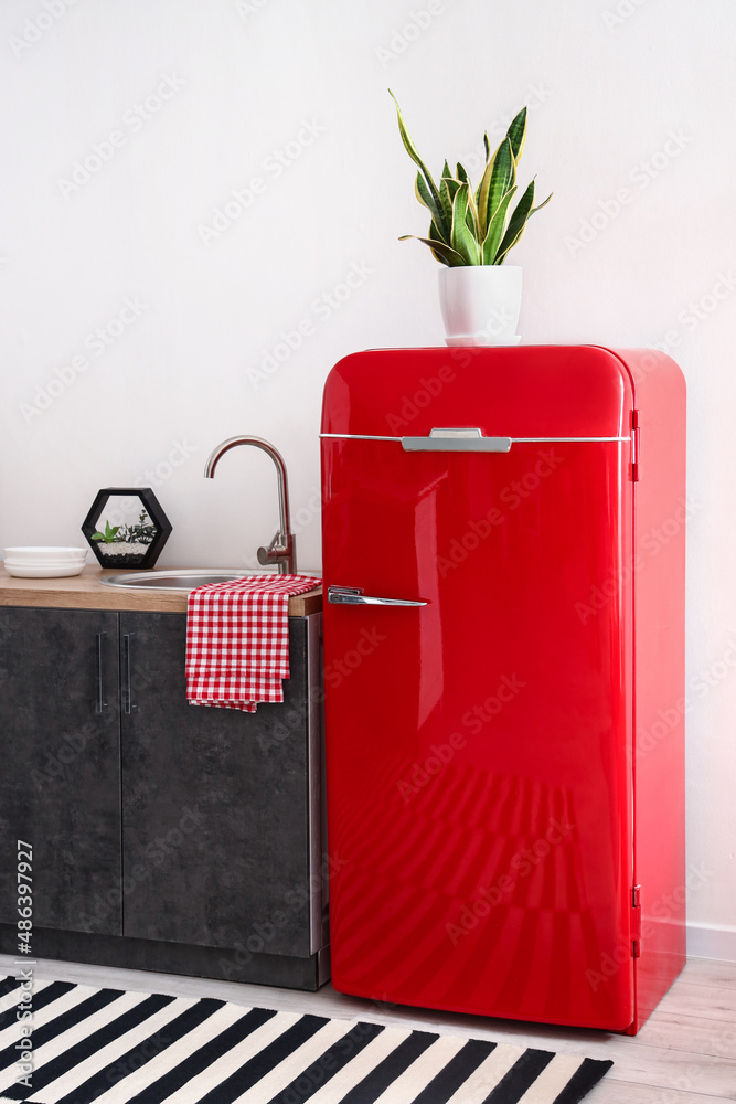 Red fridge near light wall in modern kitchen