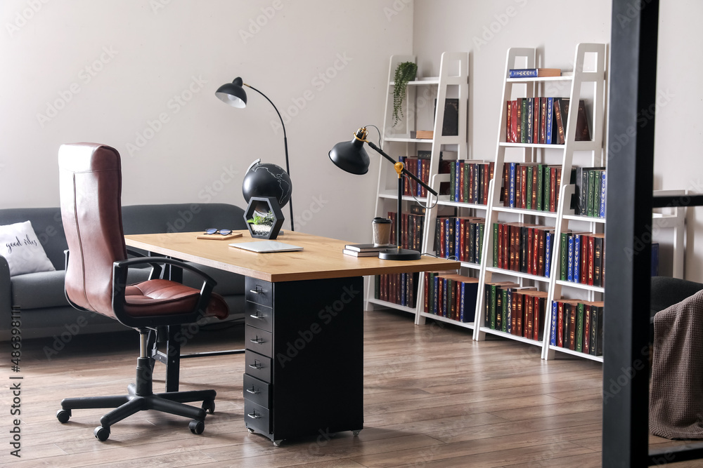 Stylish workplace and shelf unit with books in home library