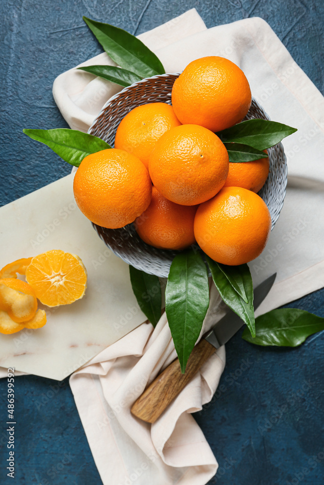 Basket with fresh juicy oranges on black background