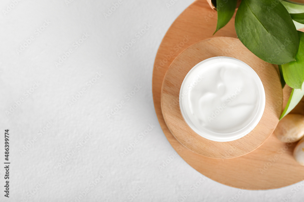 Jar with natural cosmetic cream on light background