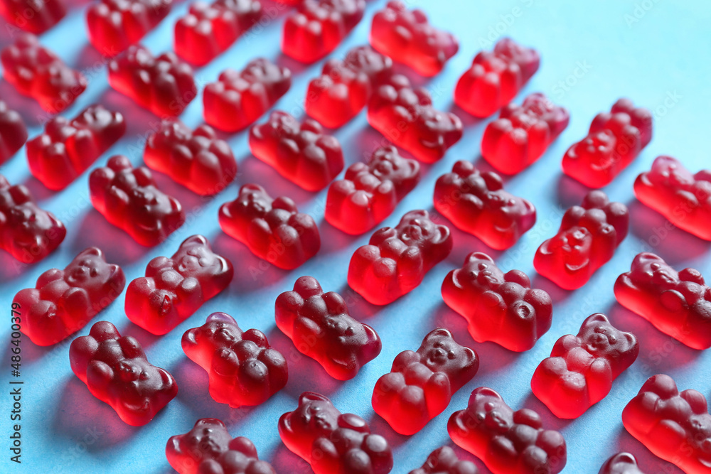 Sweet jelly bears on blue background, closeup