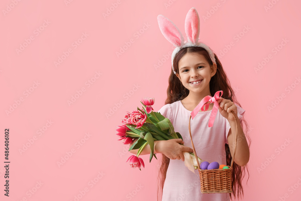 可爱的小女孩，有兔子耳朵、花朵和粉色背景的复活节篮子