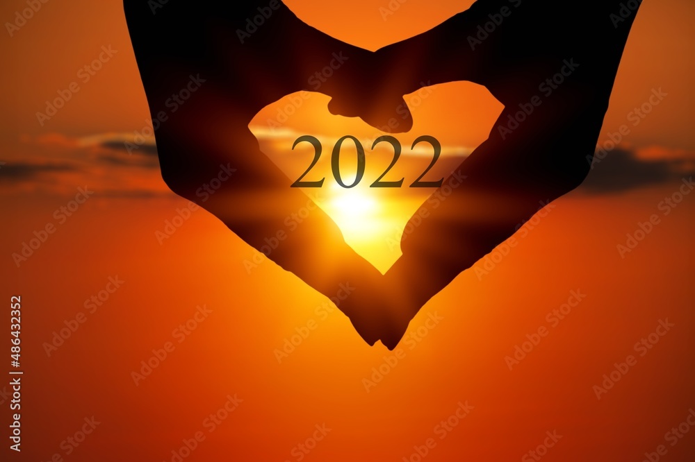 New year inspirational motivational, person holding a heart shaped hands with 2022 number inside.