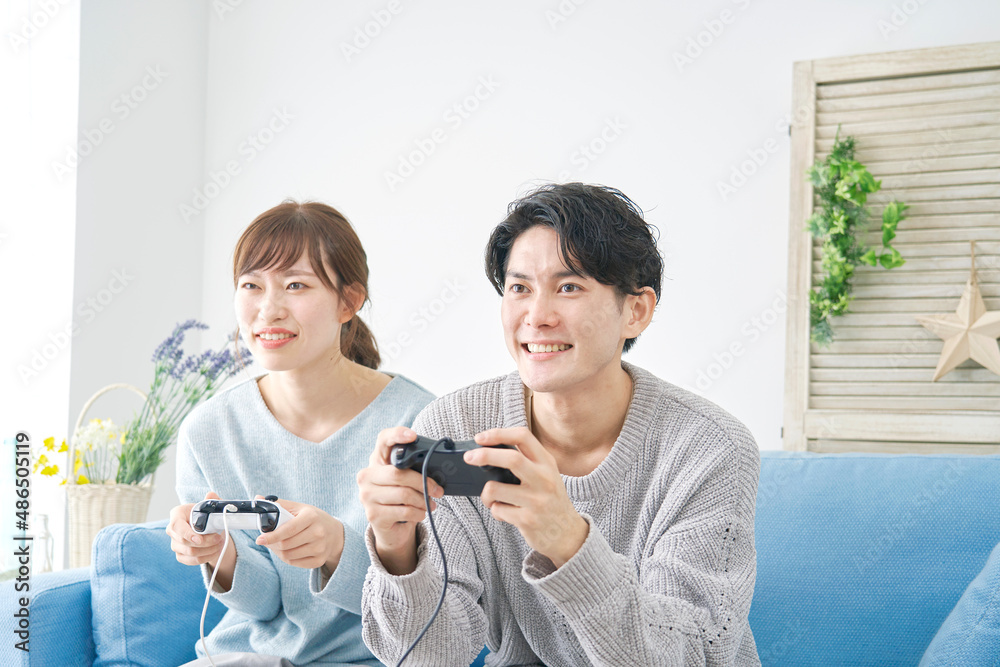 テレビゲームで遊ぶカップル