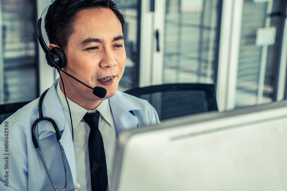 Doctor wearing headset talking actively on video call in a clinic or hospital . Concept of telehealt