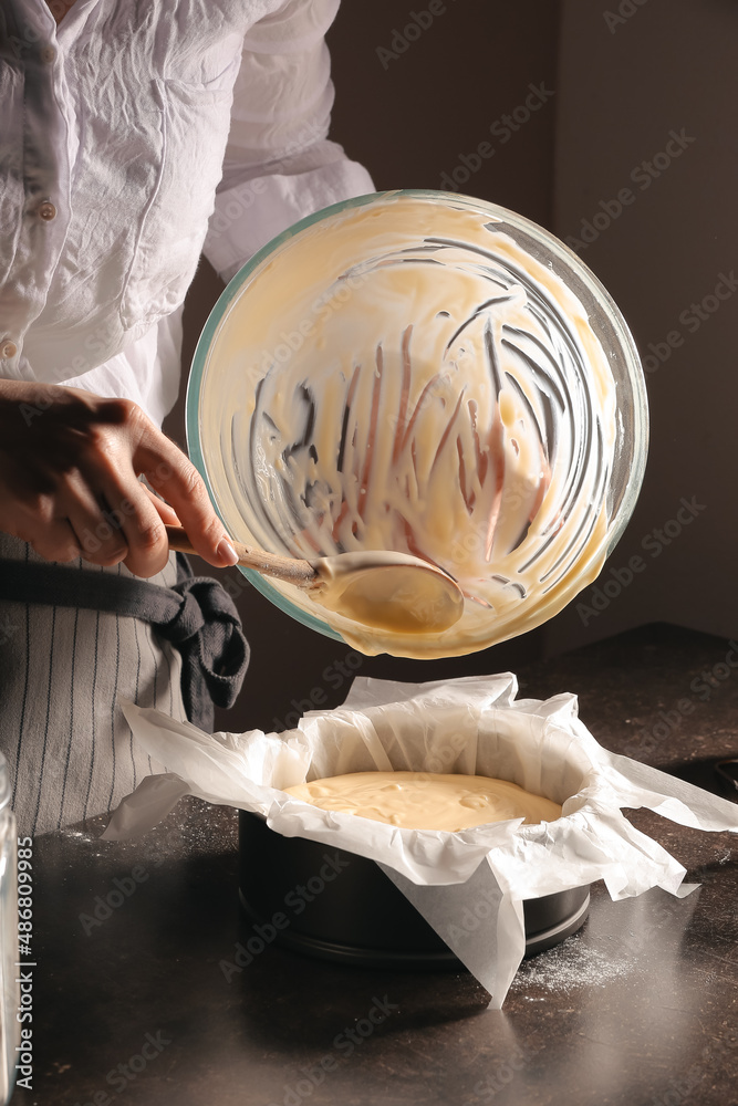 Woman preparing tasty Basque burnt cheesecake in kitchen