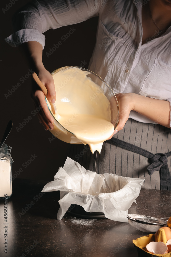 Woman preparing tasty Basque burnt cheesecake in kitchen