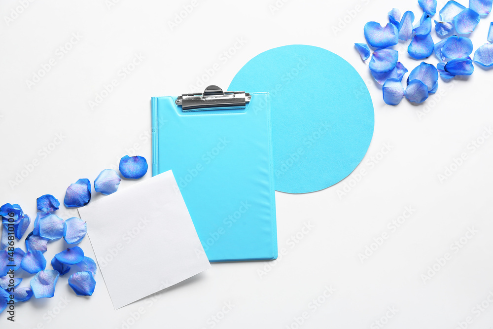 Composition with clipboard, blank cards and flower petals on white background