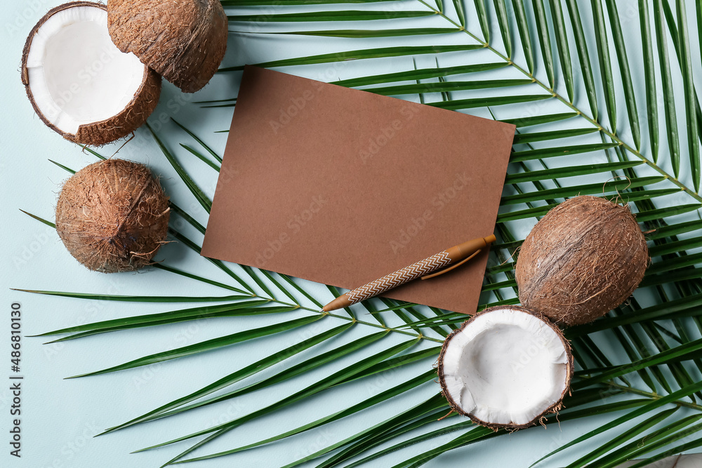 Composition with blank card, pen, coconuts and palm leaves on color background