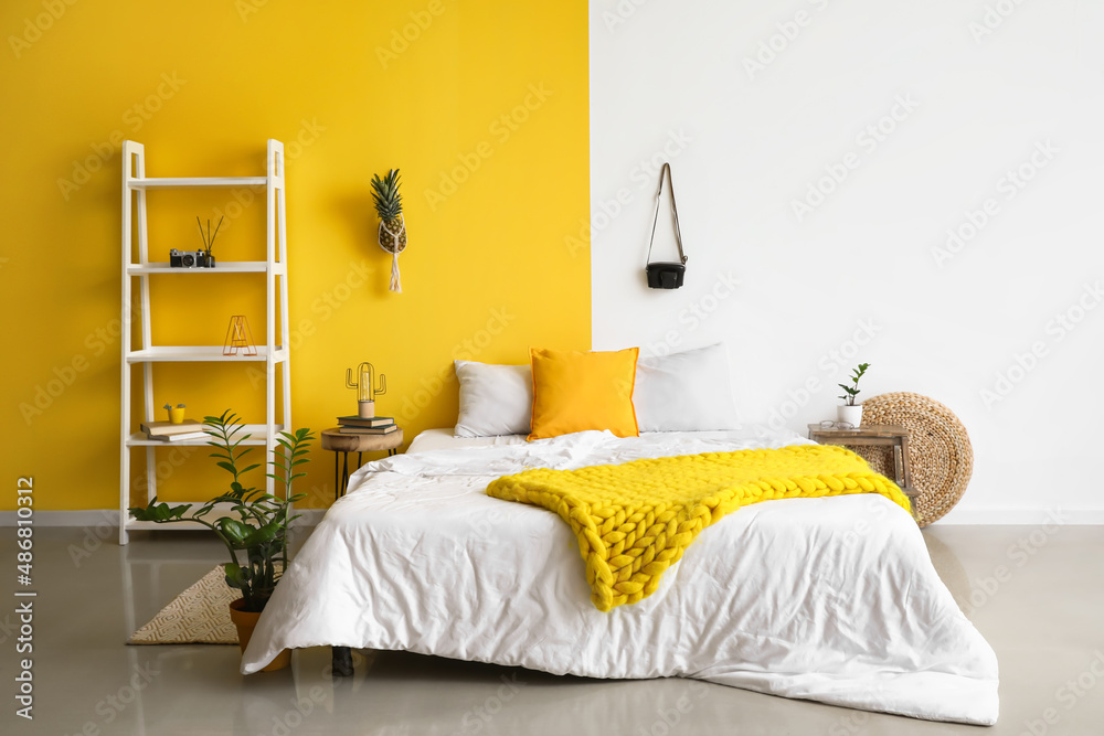 Interior of white and color bedroom with shelf unit