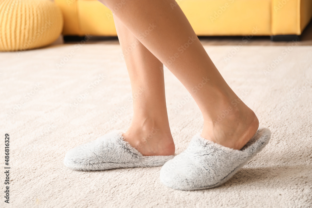 Young woman in soft comfortable slippers at home