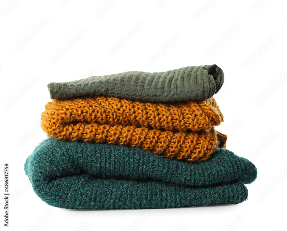 Stack of soft knitted sweaters on white background