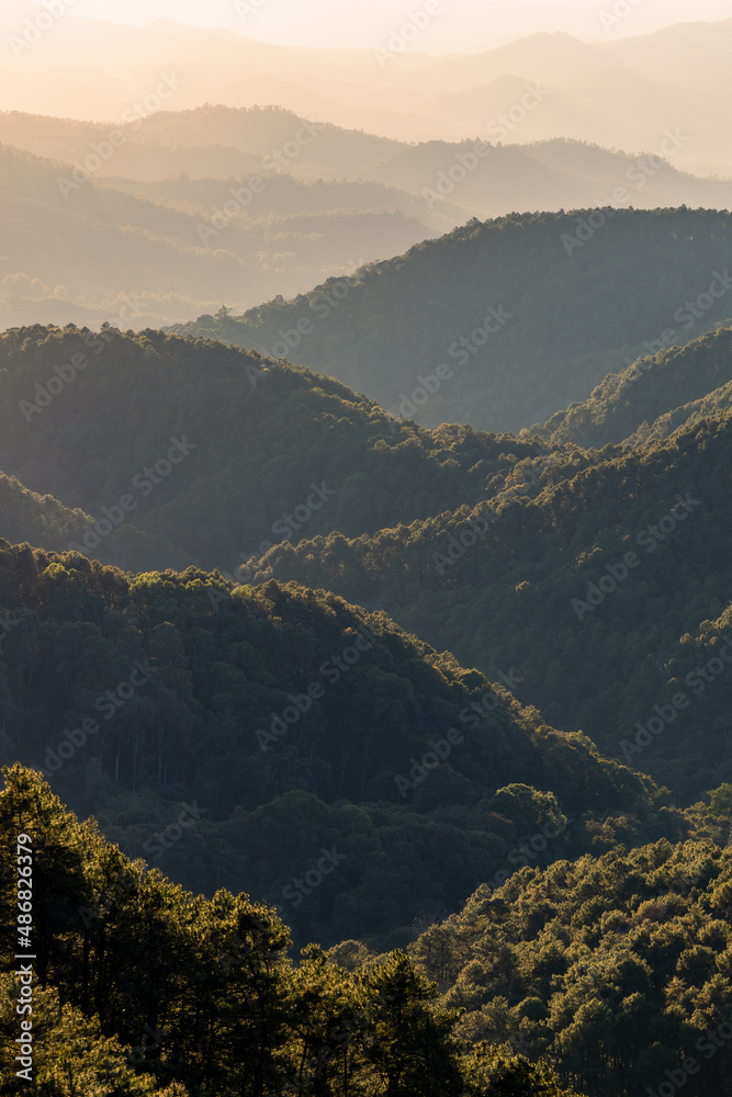 Beautiful dark orange mountain landscape with fog and forest. sunrise and sunset in mountains, Layer