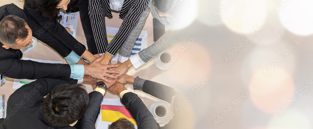 Happy business people celebrate teamwork success together with joy at office table shot from top vie