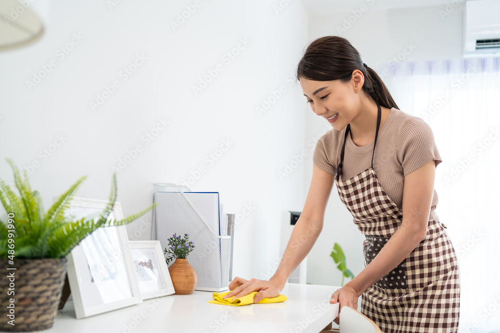 Asian cleaning service woman worker cleaning in living room at home.