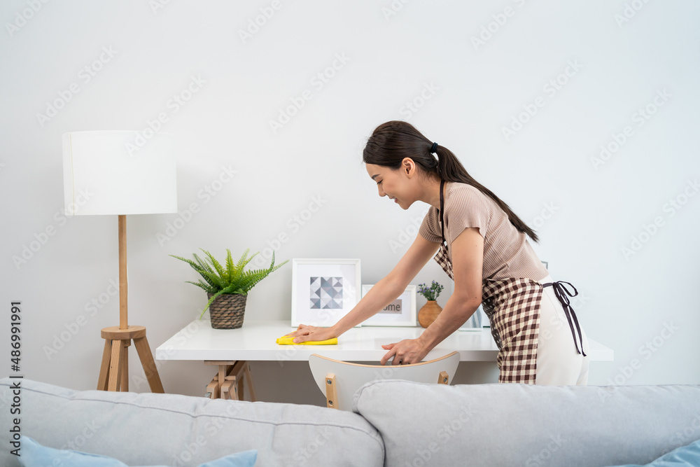 Asian cleaning service woman worker cleaning in living room at home.