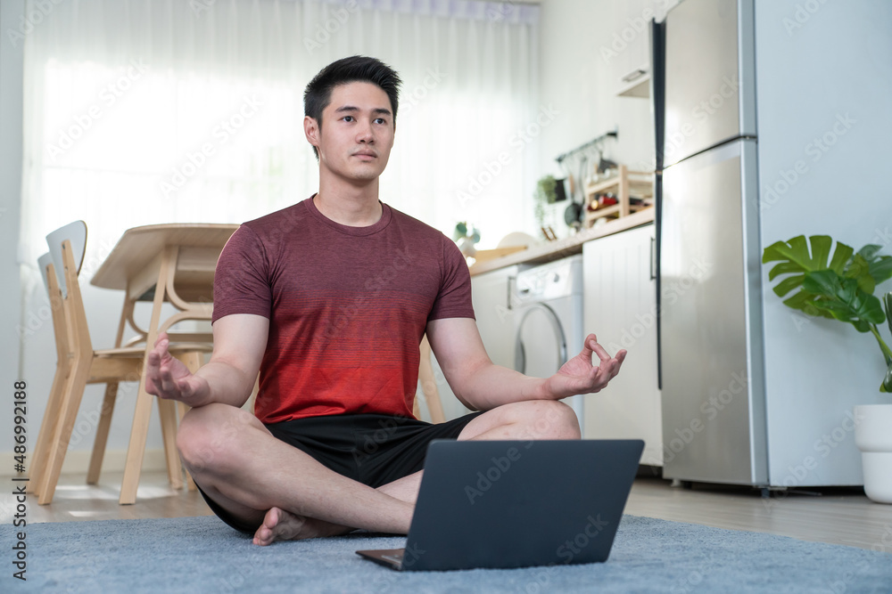 Asian handsome active young man doing exercise on floor in living room. 