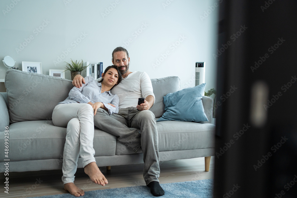 Caucasian loving couple watch movie together in living room at home. 