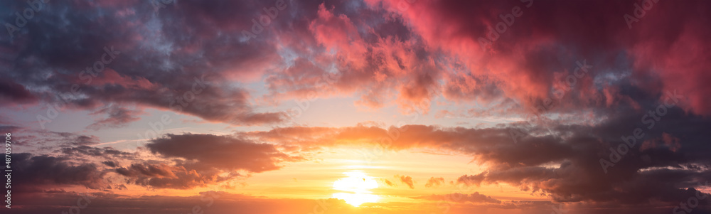 Yellow and warm sunset from gray clouds. Panorama of the dramatic evening sky above the horizon.