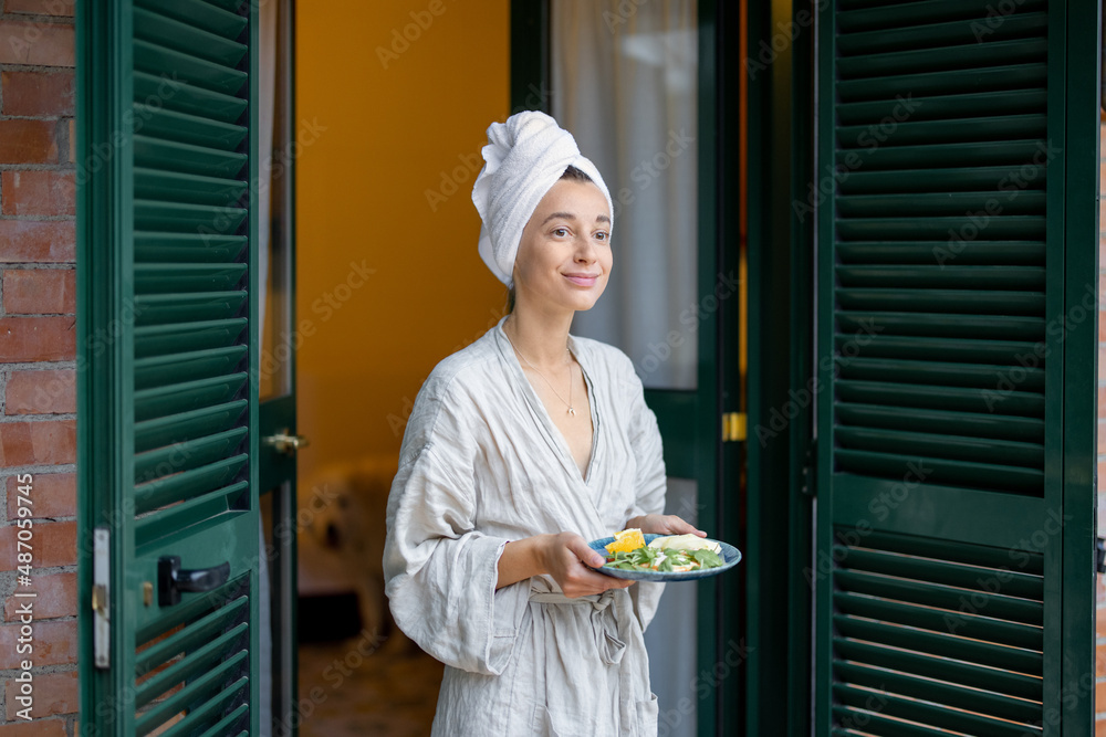 早上在酒店休息时，在户外拿着早餐的女人。周末的概念，旅游