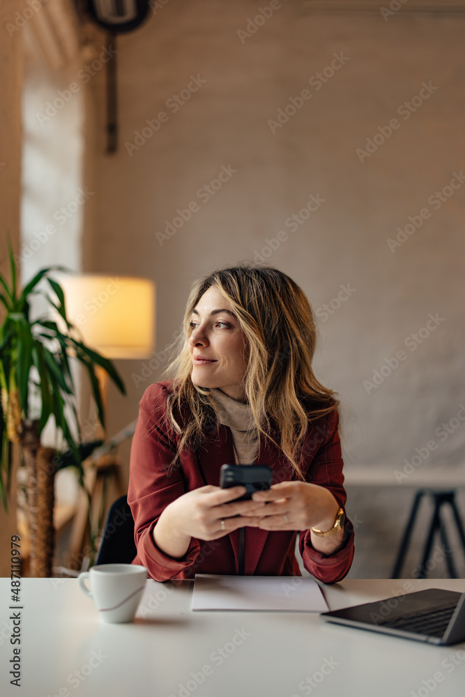 Businesswoman sitting at the cafe, finished work, using the phone.