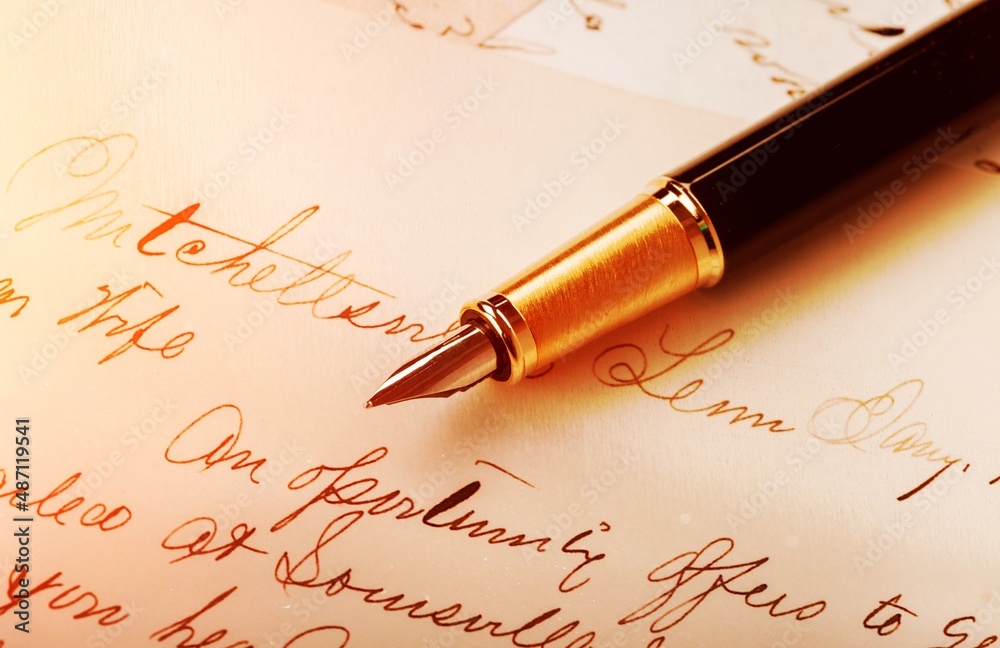 Fountain pen on an antique handwritten letter. Vintage pen and handwritten cursive style