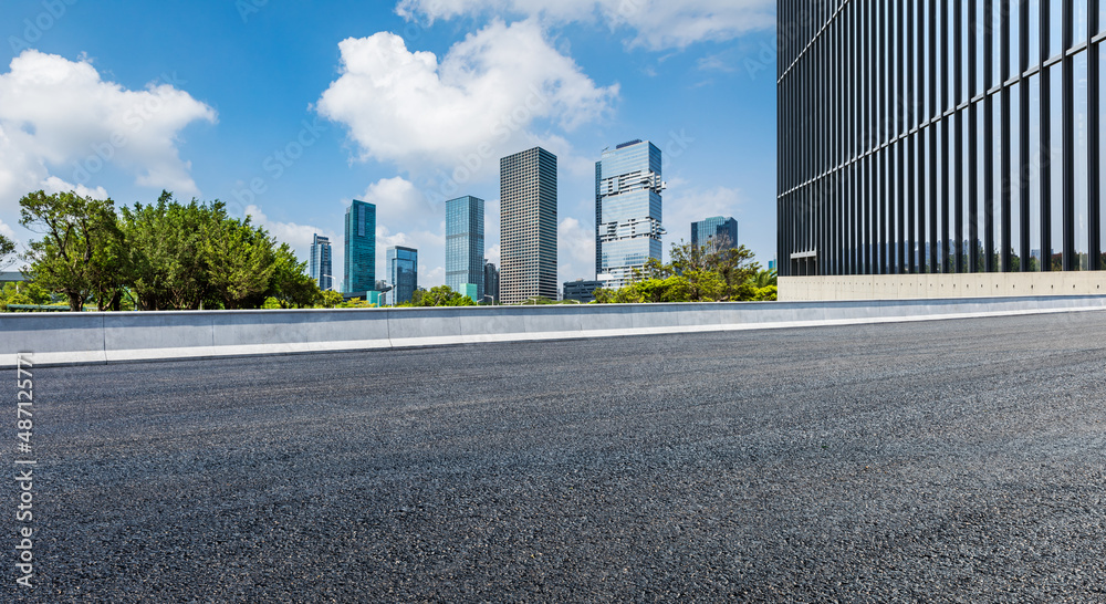 Asphalt road and city skyline with modern commercial buildings in Shenzhen, China.